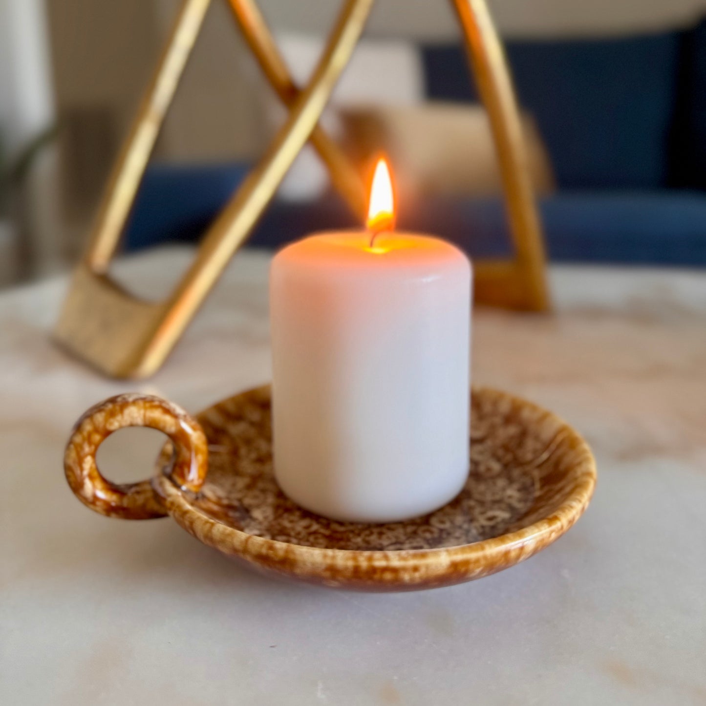 white candle over a ceramic loop holder