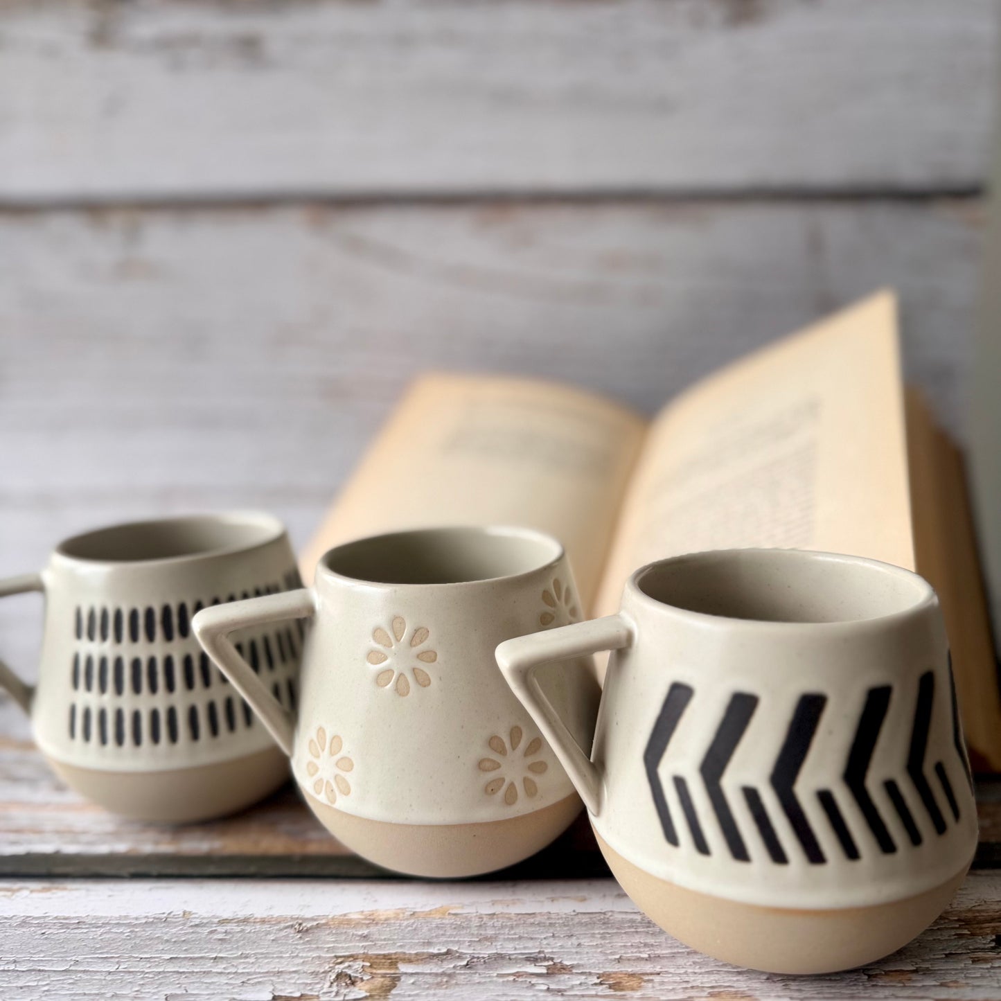 Set of ceramic mugs with geometric patterns on a wooden surface